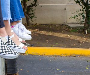 adolescenti sul muretto con scarpe in primo piano